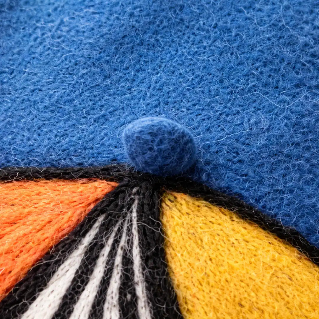 Détail du pompon en laine bleu du béret basque femme Julie avec motif multicolore feutré